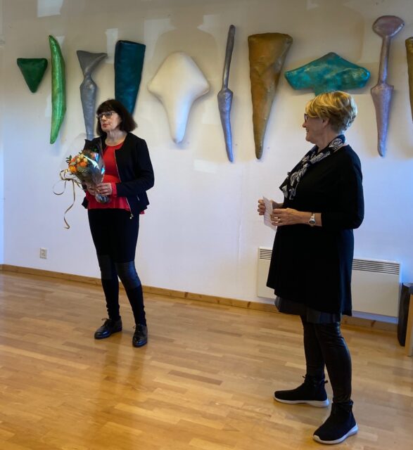 Unni Nordkild Skjønsberg, leder i kunstforeningen overrekker blomster til kunstneren